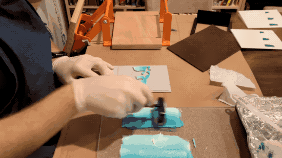 A video showing the process of applying ink to a printing plate with a roller, putting a card on the plate, pressing down on the paper, and eventually removing it showing the image on the paper.